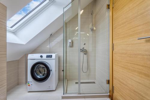 a bathroom with a shower and a washing machine at Apartman - Casa Emma- Zlatibor in Zlatibor