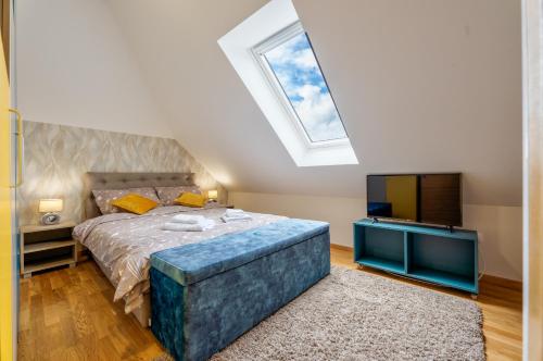 a bedroom with a large bed and a skylight at Apartman - Casa Emma- Zlatibor in Zlatibor