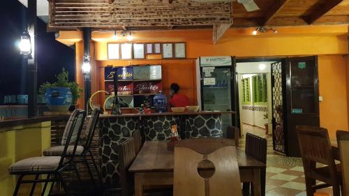 eine Bar in einem Restaurant mit einem Tisch und Stühlen in der Unterkunft We Travel Hostel in Moshi