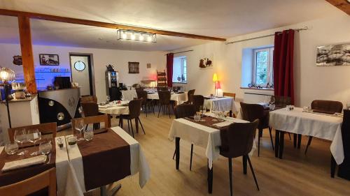 un restaurant avec des tables et des chaises avec une nappe blanche dans l'établissement Le Relais de la Comté, à Portbail