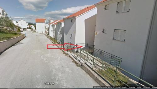 an empty street next to a white building at Afrodita in Nečujam