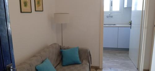 sala de estar con sofá marrón con almohadas azules en Vikos Beach Apartments, en Paralía Iríon