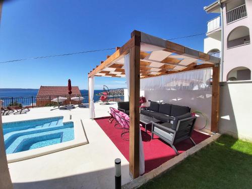 a patio with a pool and a pergola at Apartmani Zora in Trogir
