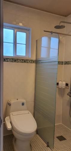 a bathroom with a toilet and a glass shower at Jeju Skyline Pension in Jeju