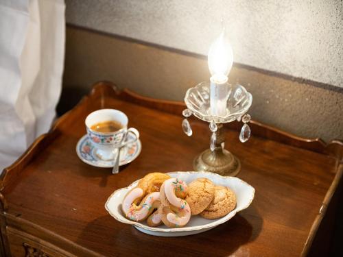 a table with a plate of cookies and a candle at PALAZZO CHERCHI in Dorgali