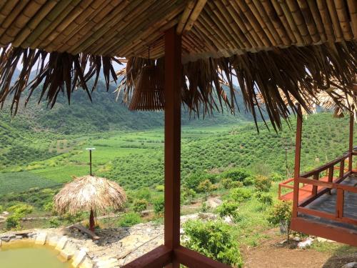 a view of a field from a straw hut at Mộc Châu Peachy Garden in An Pon