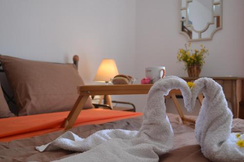 dois cisnes de toalha sentados em cima de uma cama em Bali House em Balíon