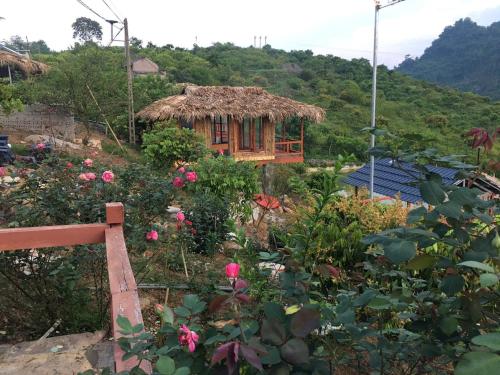 a small house in a garden with flowers at Mộc Châu Peachy Garden in An Pon