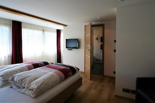 Una habitación de hotel con dos camas y un televisor. en Landhaus Alpenflair Whg 310, en Oberstdorf