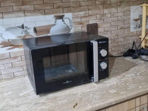 a microwave sitting on top of a counter at Gujar Khan - 3 Bed Apartment - sleeps 6 - Parking in Gūjar Khān