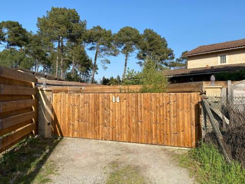 een houten hek voor een huis bij Escale sous le Chêne in Salles