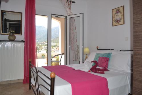 a bedroom with a bed with a pink blanket on it at Bali House in Balíon