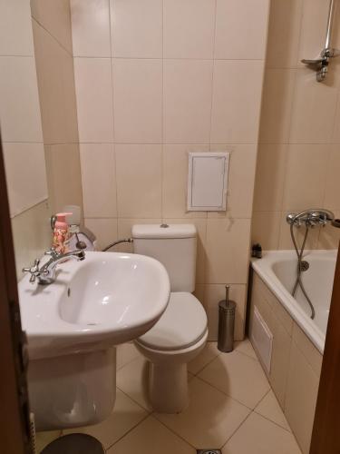 a bathroom with a white toilet and a sink at Pirin Golf Apartment HOME with private garden in Bansko
