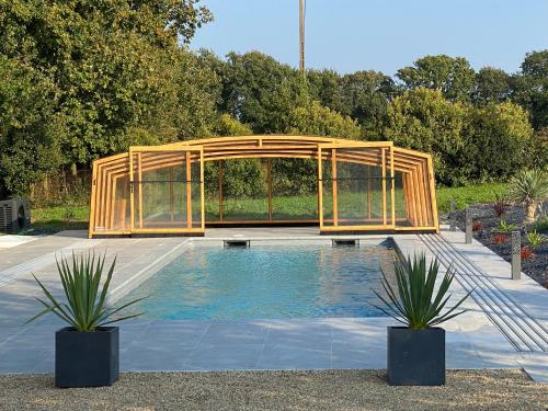 un pabellón de madera junto a una piscina en Les Chtis Bretons Chambres d hotes, en Trédion
