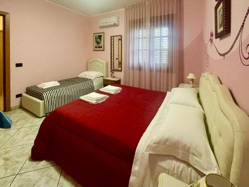 een slaapkamer met 2 bedden en een rode deken bij B&B Villa Ciccone in Villamagna