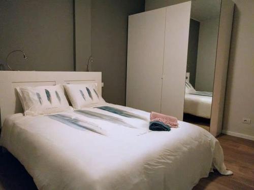 een slaapkamer met een groot wit bed met een spiegel bij Bellavista Lago Maggiore in Cerro Lago Maggiore