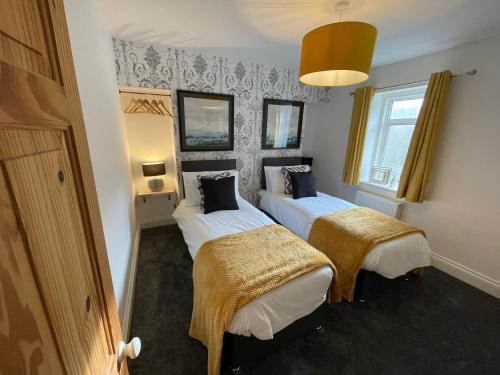 a room with two beds in a room at Cheerful 2 Bedroom Townhouse with Cinema Loft in Pembrokeshire