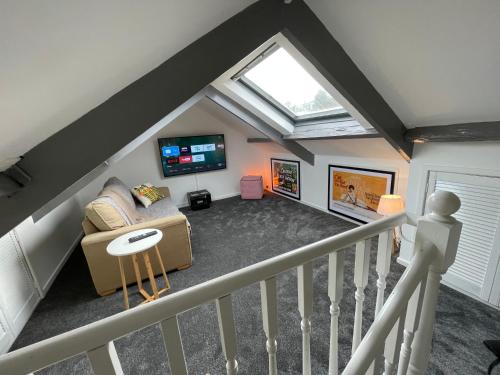 a attic room with a couch and a tv at Cheerful 2 Bedroom Townhouse with Cinema Loft in Pembrokeshire