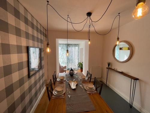 a dining room with a long wooden table with chairs at Cheerful 2 Bedroom Townhouse with Cinema Loft in Pembrokeshire