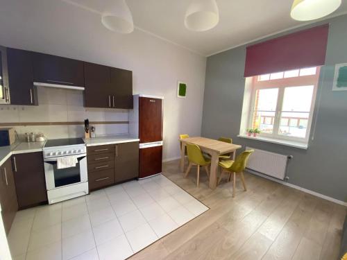 una cocina con una mesa y una estufa horno superior en Apartament Czos, en Mrągowo
