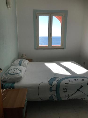a bedroom with a large bed with a window at belvedere acqua dolce 1 in Cala Gonone