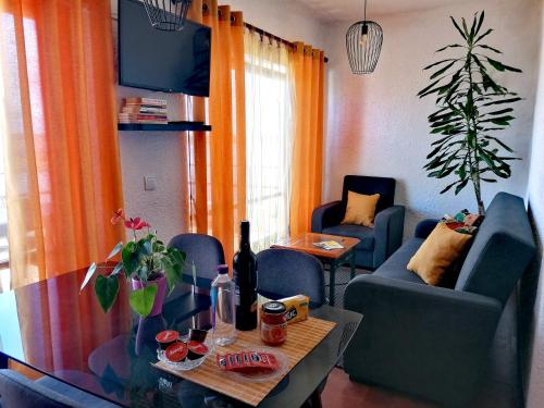 een woonkamer met stoelen en een tafel met een fles wijn bij Barrinha_Village in Praia de Mira