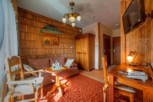 a living room with a couch and a table at Hotel Carpatia Bieszczadzki Gościniec in Wetlina