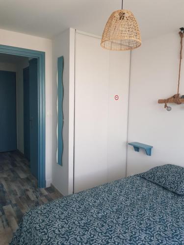 a bedroom with a blue bed and a lamp at Appartement Royan, 200 m de la PLAGE in Royan