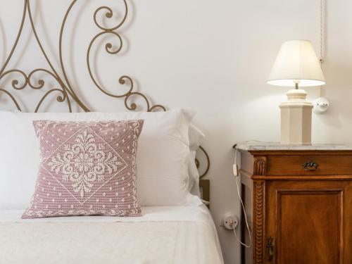 a bed with a pillow and a lamp on a night stand at PALAZZO CHERCHI in Dorgali
