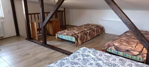 an attic room with three beds and a mirror at Apartament typu studio Niepodległości Sopot in Sopot