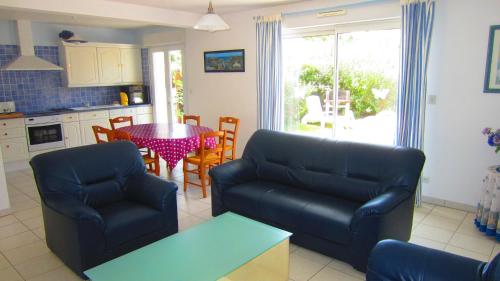 un salon avec un canapé et une table dans l'établissement Maison avec jardin à 80 m de la plage de Barneville-Carteret, à Saint-Jean-de-la-Rivière