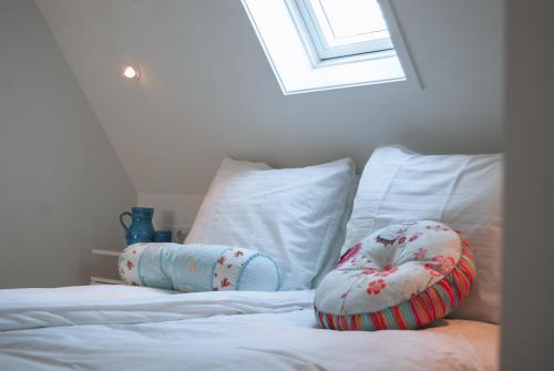 a bed with two pillows on top of it at Schitterend appartement HartVanDomburg in Domburg