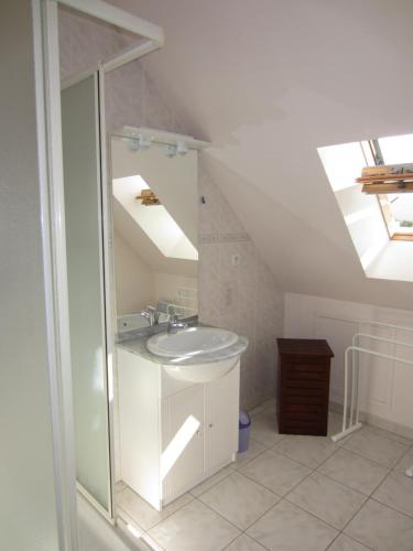 La salle de bains est pourvue d'un lavabo et d'une lucarne. dans l'établissement Maison avec jardin à 80 m de la plage de Barneville-Carteret, à Saint-Jean-de-la-Rivière