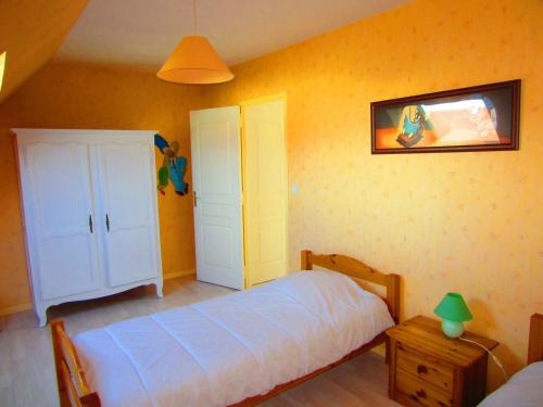 une chambre avec un lit et un tableau au mur dans l'établissement Maison avec jardin à 80 m de la plage de Barneville-Carteret, à Saint-Jean-de-la-Rivière