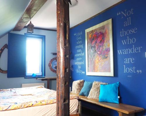 1 dormitorio con cama y pared azul en The Old Barn - uroczy, butikowy dom w malowniczej wsi, dla rodzin lub grup przyjaciół z basenem en Płóczki Górne
