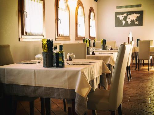 a dining room with tables and chairs with white tablecloths at Albergo Antica Corte Marchesini in Campagna Lupia