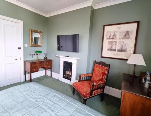 a living room filled with furniture and a fireplace at Villa Rothsay Hotel in Cowes