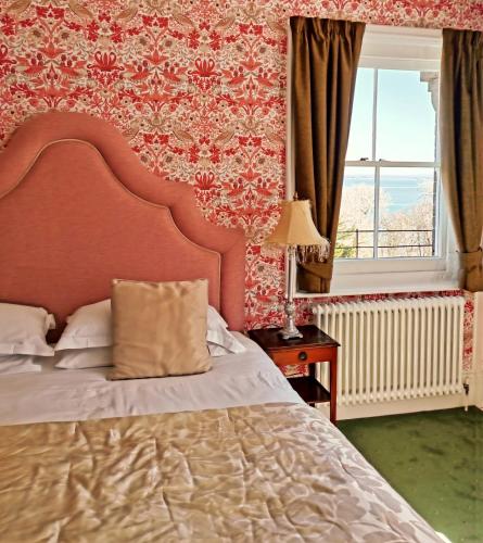a bedroom with a large bed and a window at Villa Rothsay Hotel in Cowes