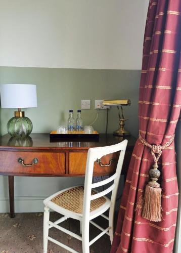 a desk with a chair and a table with a lamp at Villa Rothsay Hotel in Cowes