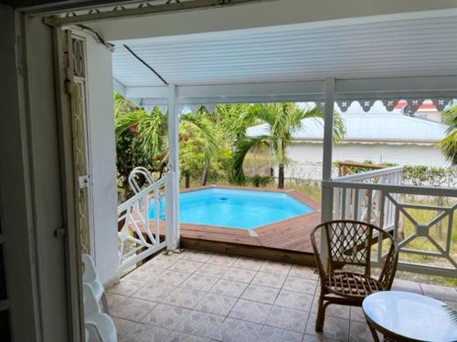 a patio with a pool and a table and chairs at Villa spacieuse avec piscine privée - Le Vauclin in Le Vauclin