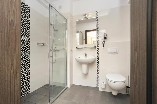 a bathroom with a toilet and a sink at Kalinowe Pola Golf Village in Niesulice