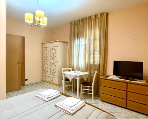 ein Wohnzimmer mit einem Tisch und einem TV sowie ein Zimmer in der Unterkunft B&B Villa Ciccone in Villamagna