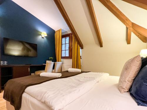 two beds in a bedroom with a blue wall at Templomvölgy Butik Hotel Mátrakeresztes in Matrakeresztes
