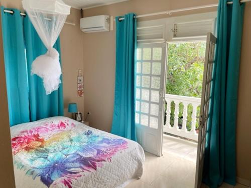 a bedroom with a colorful bed and a window at Villa spacieuse avec piscine privée - Le Vauclin in Le Vauclin