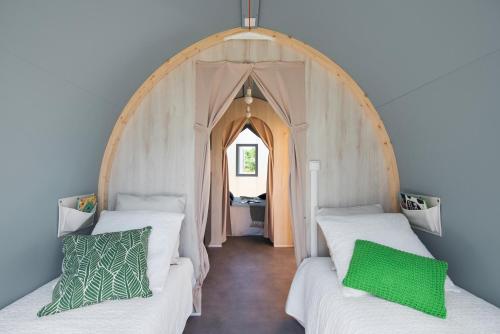2 łóżka pojedyncze w pokoju z łukiem w obiekcie camping feniglia w mieście Monte Argentario