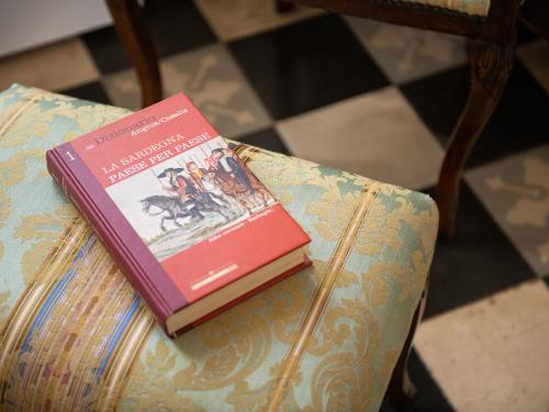a book is sitting on top of a couch at PALAZZO CHERCHI in Dorgali