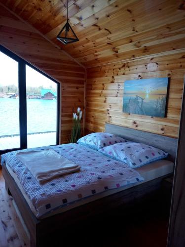 a bedroom with a bed in a wooden cabin at House ThoNi in Gornji Štoj