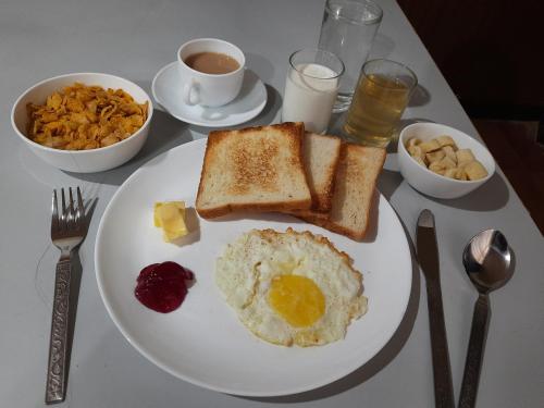 un plato blanco con huevos y tostadas en una mesa en Kanari B&B, en Darjeeling