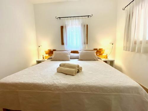 Una cama blanca grande con una toalla. en Campanitx Villas - Astbury Formentera, en Es Caló