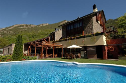 uma casa com piscina em frente a um edifício em Hotel Riberies & SPA em Llavorsí